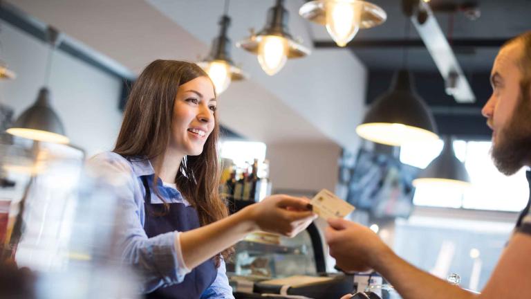 kvinder modtager kortbetaling for mand i en cafe